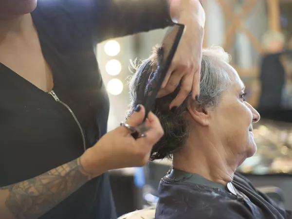 Peinado y corte en cliente en el sillón del salón